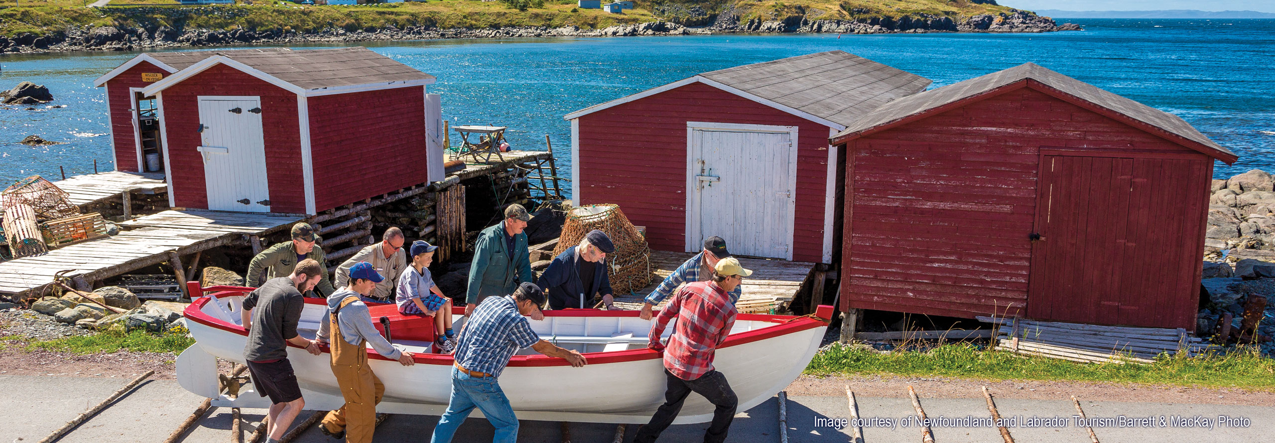 Image courtesy of Newfoundland and Labrador Tourism and Barrett & MacKay Photo Men working together to launch a boat